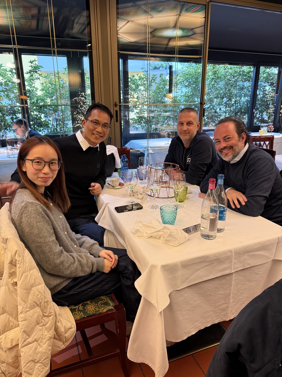 Four people seated together at a restaurant table
